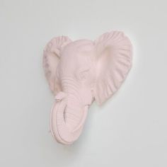 a pink elephant head mounted on the wall