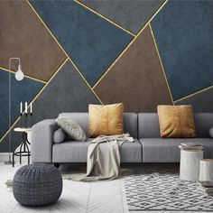 a modern living room with grey couches and gold accented wallpaper on the walls