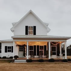 a white house with lights on the front porch