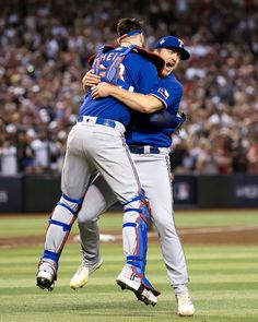 two baseball players are hugging each other on the field