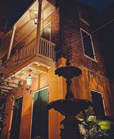 a building with a fountain in front of it at night