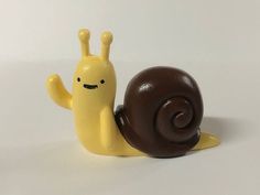 a snail figurine sitting on top of a chocolate covered object with eyes closed