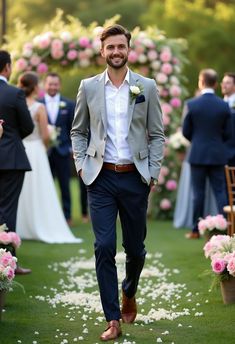 a man in a suit and tie walking down the aisle with flowers on either side