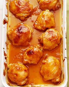 meatballs covered in gravy and sauce in a white casserole dish