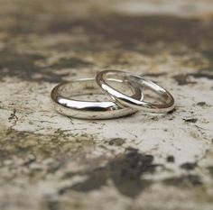 two wedding rings sitting on top of a dirty surface