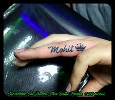 a woman's hand with a small tattoo that reads molit on the middle finger