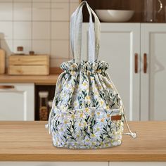 a white purse sitting on top of a wooden table next to a kitchen countertop