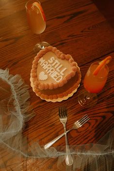 a table topped with a cake next to a glass of orange juice and a fork