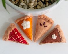 three slices of felt pizza sitting on top of a table next to a potted plant