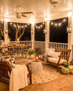 a porch with wooden furniture and lights on the ceiling