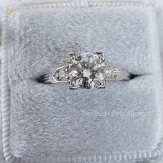 an old - fashioned diamond ring sits on top of a furnishe cushioned box