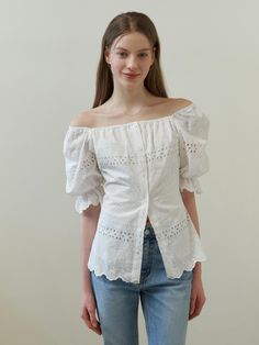 This clothing item is a dress with dramatic puff sleeves and an off-the-shoulder neckline. It features a button-up front and is adorned with eyelet lace detailing throughout, providing a see-through effect on the sleeves and hem. The hemline showcases a scalloped edge, enhancing the dress's feminine charm.- The eyelet lace detailing creates a delicate and airy feel, perfect for warm weather.- Its off-the-shoulder design and puff sleeves add a trendy and romantic touch.- The scalloped hemline con Summer Eyelet Blouse With Puff Sleeves, Spring Eyelet Blouse With Puff Sleeves, Princess Wardrobe, Disney Princess Modern, White Shirt Blouse, Eyelet Blouse, Fashion Top Outfits, White Lace Blouse, Modern Disney