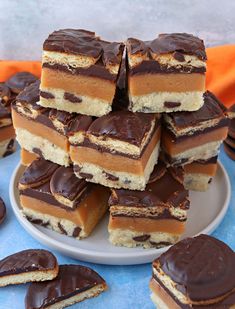 a white plate topped with pieces of cake next to chocolate frosting on top of each other