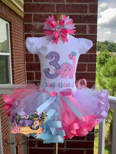 a pink and blue birthday dress on top of a mannequin