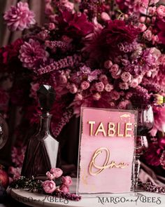 a table topped with pink flowers and bottles