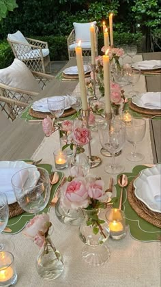 the table is set with flowers and candles on it for an elegant dinner or party