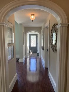 an archway leading into a house with wood floors and hard wood flooring on both sides