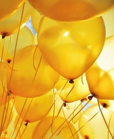 many yellow balloons are floating in the air