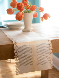 a vase with flowers on top of a wooden table