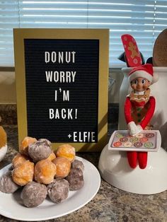 an elf with donuts on a plate next to a sign that says donut worry i'm back