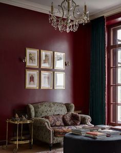 a living room filled with furniture and a chandelier hanging from the ceiling next to a window