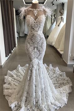 a white wedding dress with feathers on it