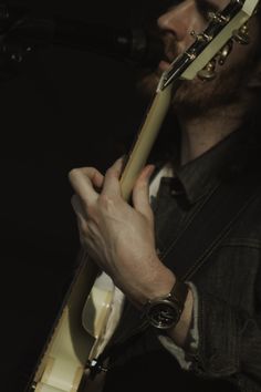 a man holding a guitar in his right hand