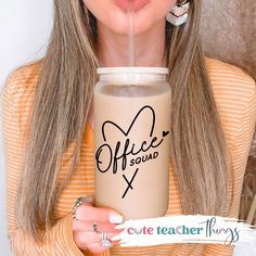 a woman holding a coffee cup with the word office squad on it's side