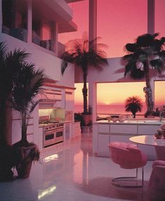 an open kitchen and living room area with palm trees in the background at sunset or dawn