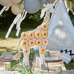 a table topped with donuts and a giraffe statue