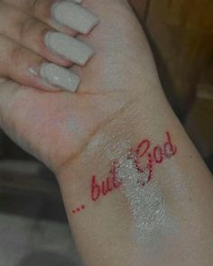 a woman's arm with red writing on it and the words but god written on it