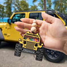 a hand holding a jeep with beads on it