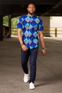 Step up your casual wardrobe with our Aire African Print Men's Shirt, a perfect fusion of tradition and modern style. This handmade shirt features a striking Ankara print in a geometric pattern, adding a touch of vibrant African culture to your look. The short sleeve design and concealed buttons make it ideal for warm weather, while the comfortable cotton fabric ensures all-day ease. Whether you're dressing up for a casual outing or keeping it simple at home, this shirt is versatile enough to su Blue Cotton Shirt With Geometric Pattern, Blue Short Sleeve Top With Geometric Pattern, Modern Short Sleeve Patterned Shirt, Blue Cotton Tops With Geometric Pattern, Blue Cotton Top With Geometric Pattern, Fitted Blue Top With Geometric Pattern, Cotton Shirt With Geometric Pattern And Relaxed Fit, Cotton Shirt With Relaxed Fit And Geometric Pattern, Casual Short Sleeve Shirt With Geometric Pattern