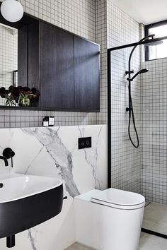 a white toilet sitting next to a black sink