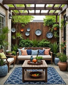 an outdoor living area with couches, tables and potted plants