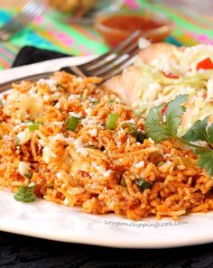 a white plate topped with rice covered in sauce and garnished with cilantro