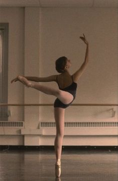 a young ballerina is practicing her ballet moves