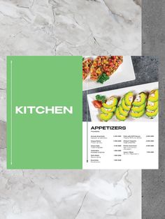 the kitchen menu is displayed on a marble table top with green and white accents, along with an assortment of appetizers