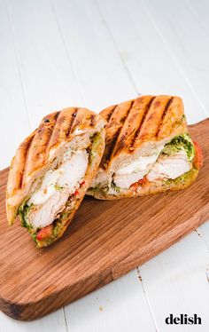 a cut in half sandwich sitting on top of a wooden cutting board