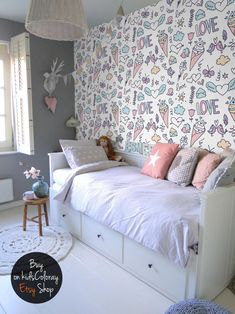 a white bed sitting in a bedroom next to a wall with cartoon drawings on it