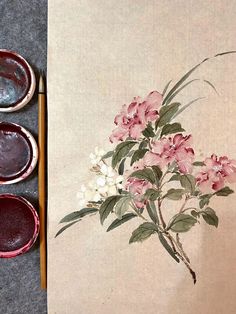 three bowls with flowers painted on them next to paintbrushes