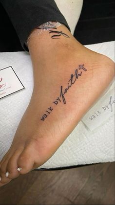 a woman's foot with the words walk by faith written on her left side