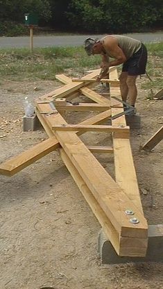 a man working on some wooden beams in the dirt