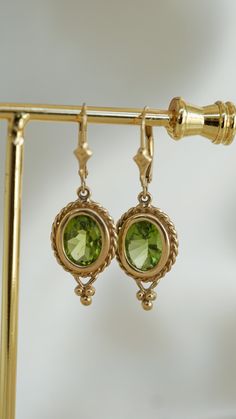 Classic Green Peridot Earrings, Gold Peridot Earrings Fine Jewelry, Classic Gold Peridot Jewelry, Classic Gold Jewelry With Peridot, Green 14k Gold Dangle Earrings, Gold Peridot Gemstone Earrings, Peridot Dangle Earrings In Gold, Peridot Drop Earrings For May Birthstone, Hallmarked 14k Gold Green Earrings