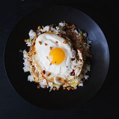 an egg and rice dish on a black plate