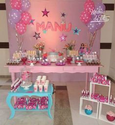 a pink table topped with lots of desserts and balloons