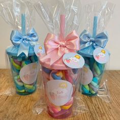 three plastic bags filled with candy on top of a wooden table