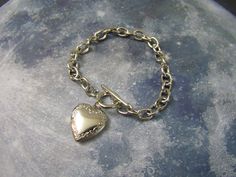 "Dainty Heart Shaped Locket on a chunky toggle closure bracelet, very y2k, super cute Stainless Steel Locket on an Alloy Bracelet Fits up to 7\" Wrist (message me for custom order length, different charm placement, different charm style etc) Photo space is approximately: Across the widest part of the heart is 13.5mm. down the center line of the heart at the pointy parts is 10.5mm Comes in a gift box, arrives safely and easy to give as a gift Goth Gothic Wedding Witch Witchy Retro Unique Handmade Heart Shaped Toggle Clasp Bracelet For Gift, Heart Shaped Bracelet With Toggle Clasp As Gift, Heart-shaped Charm Bracelet With Toggle Clasp As Gift, Heart Charm Bracelet With Toggle Clasp For Gift, Metal Heart Bracelet With Toggle Clasp As Gift, Valentine's Day Heart Bracelet With Toggle Clasp, Valentine's Day Gift Heart Bracelet With Toggle Clasp, Valentine's Day Gift Bracelet With Toggle Clasp, Heart Shaped Locket