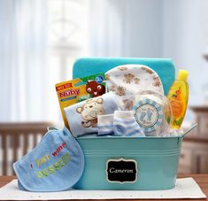 a baby's gift basket sitting on top of a table next to a blue blanket