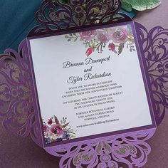 a purple and white wedding card with flowers on it